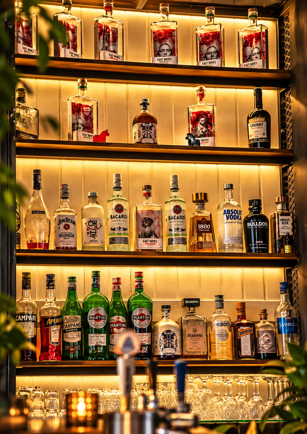 The Bar at Café Smörgås in Sanur, Bali, with a warmly illuminated selection of spirits