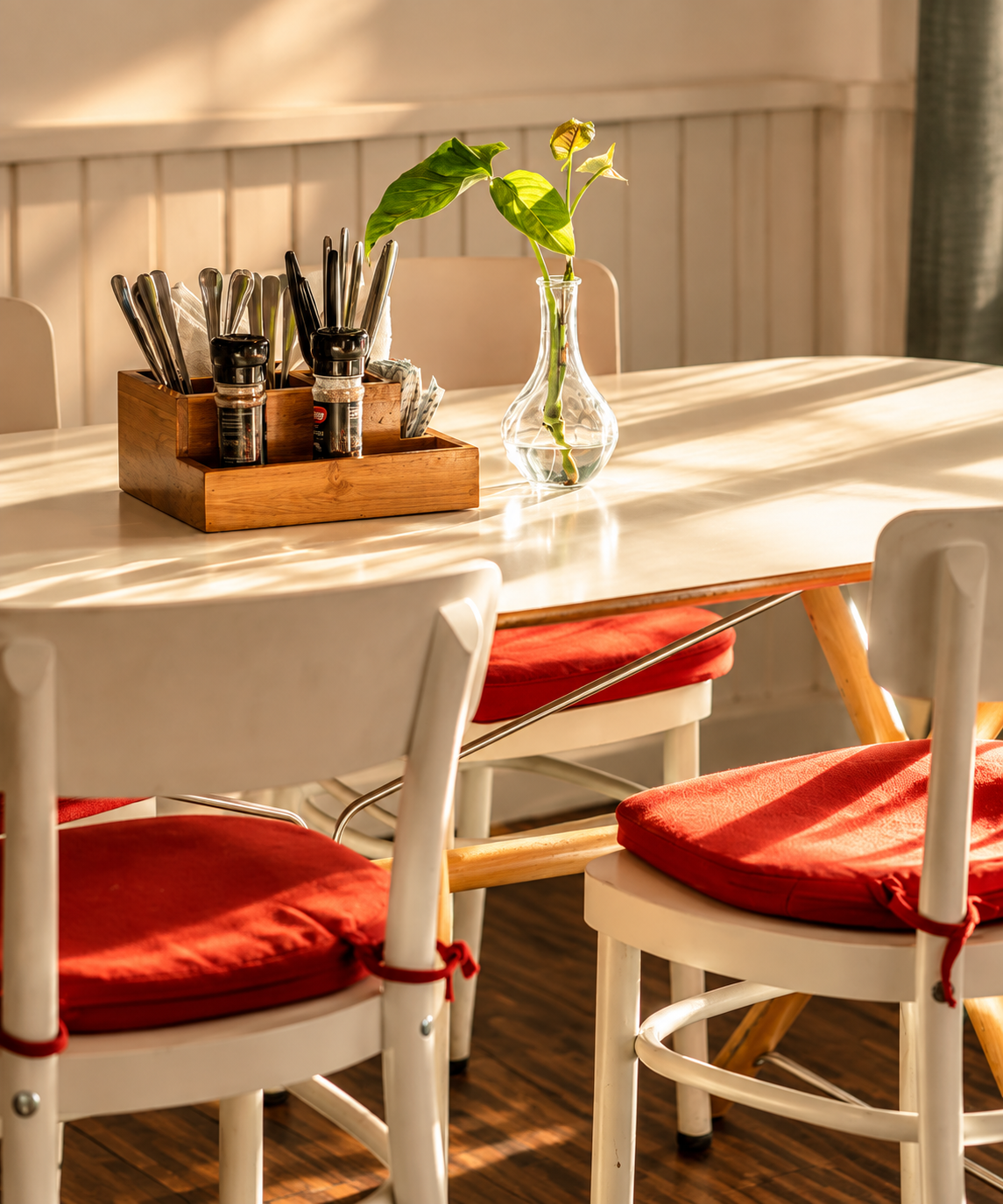 Sunlit Scandinavian café table with red cushions inside Café Smörgås in Sanur, Bali